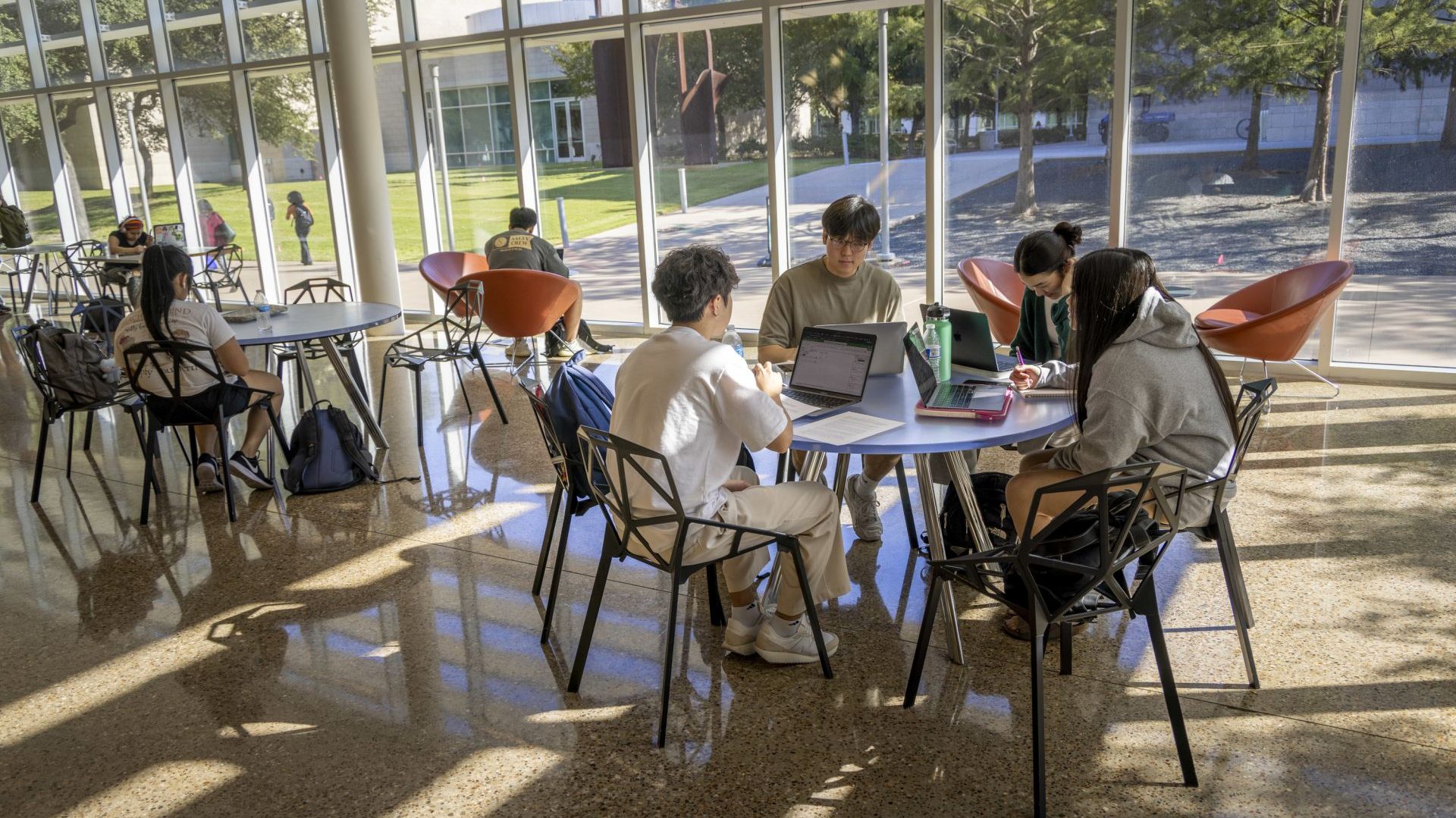 Students sitting together at various tables in the Student Union